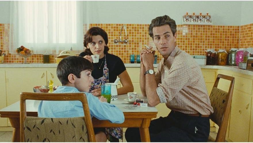 scena tratta da un film con una famiglia di tre persone a tavola