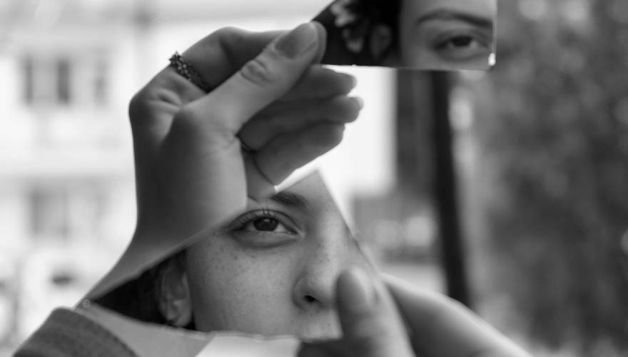 ragazza riflessa in pezzi di specchio